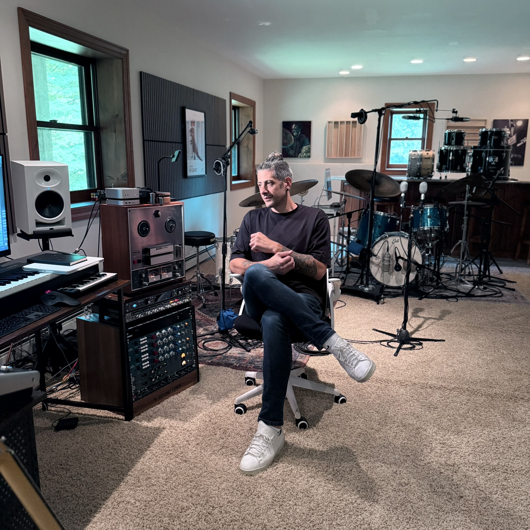 Matias Menarguez seated in his Mount Olive music studio